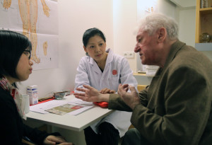 在布拉格市中心的同仁堂门店内，中国医生正在为一名捷克老人问诊。人民日报记者管克江摄